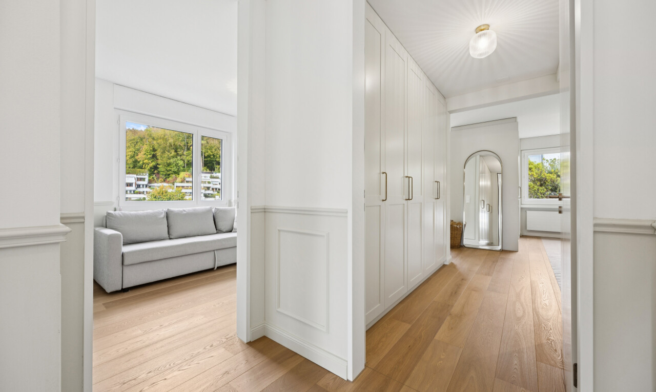 couloir avec light floor, wood finish floor, sol en finition bois, drywall, et cloison sèche