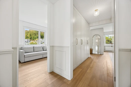 couloir avec light floor, wood finish floor, sol en finition bois, drywall, et cloison sèche