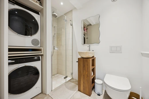 salle de bains avec douche, salle de bain complète, miroir, lave-linge et sèche-linge superposés, et drywall