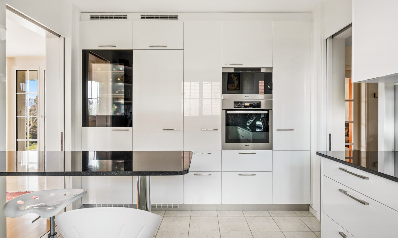 küche mit weiße schränke, ofen, schränke mit flachen paneelen, weinkühler, und inside property