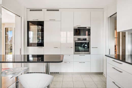 küche mit weiße schränke, ofen, schränke mit flachen paneelen, weinkühler, und inside property