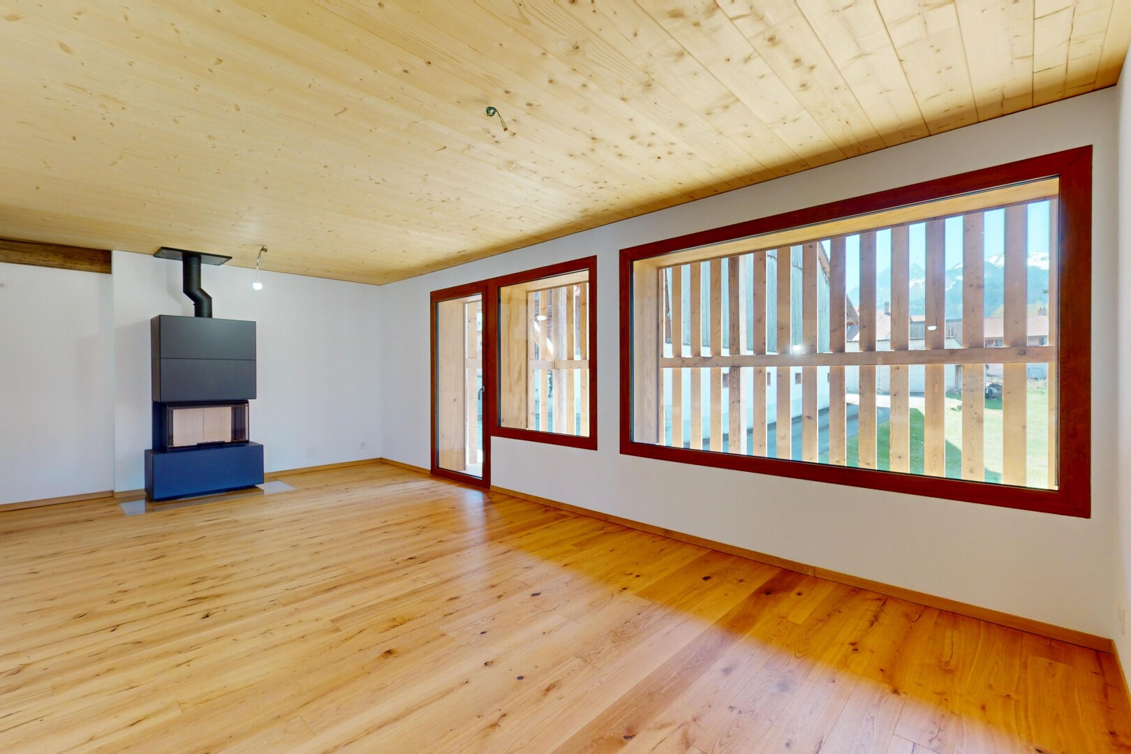 pièce vide avec lumière naturelle, plafond en bois, cloison sèche, et sol en finition bois