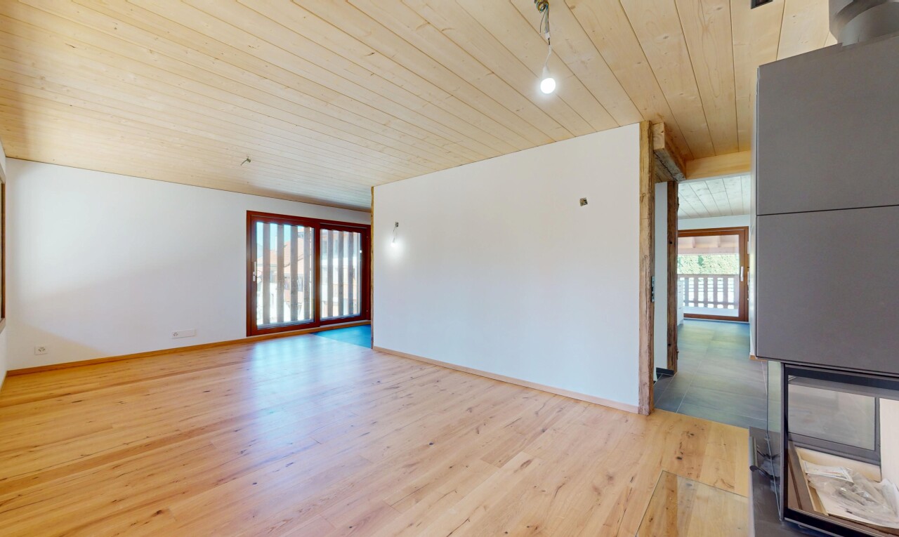 pièce vide avec lumière naturelle, plafond en bois, cloison sèche, et sol en finition bois