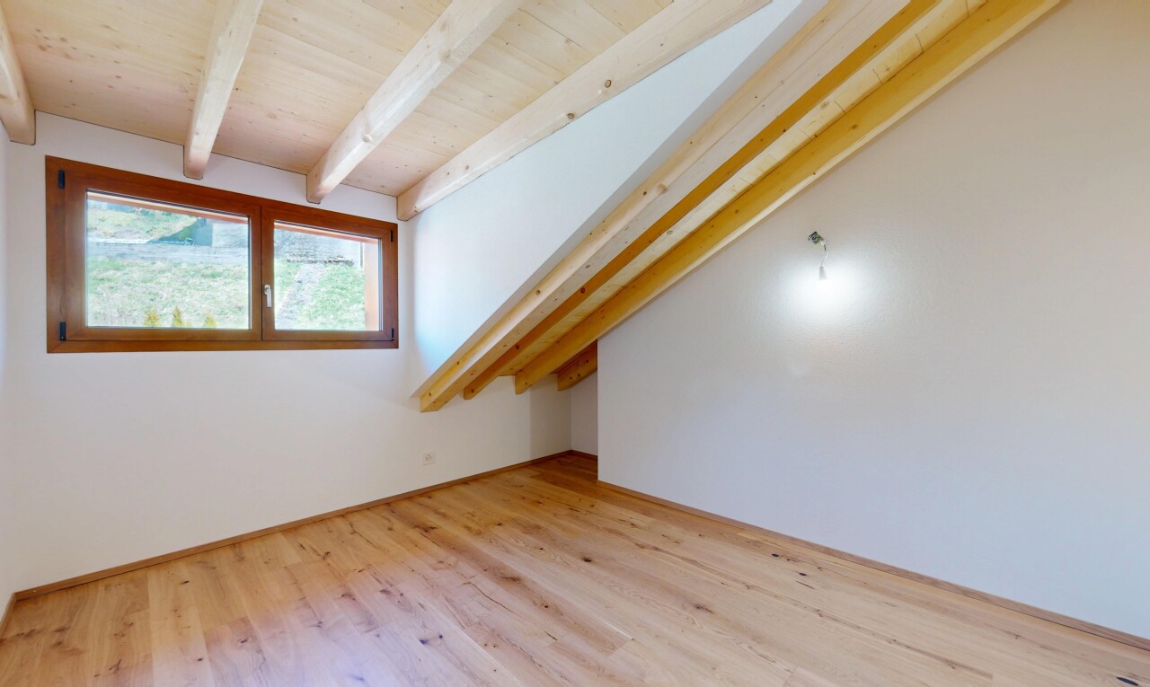 pièce vide avec cloison sèche, lumière naturelle, sol en finition bois, plafond à poutres, et plafond en bois
