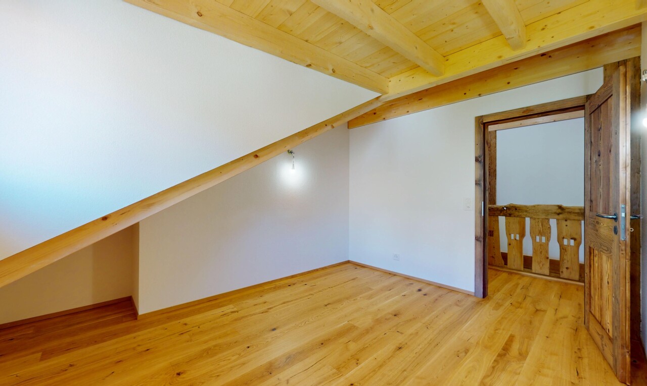 pièce vide avec cloison sèche, plafond en bois, plafond à poutres, et sol en finition bois