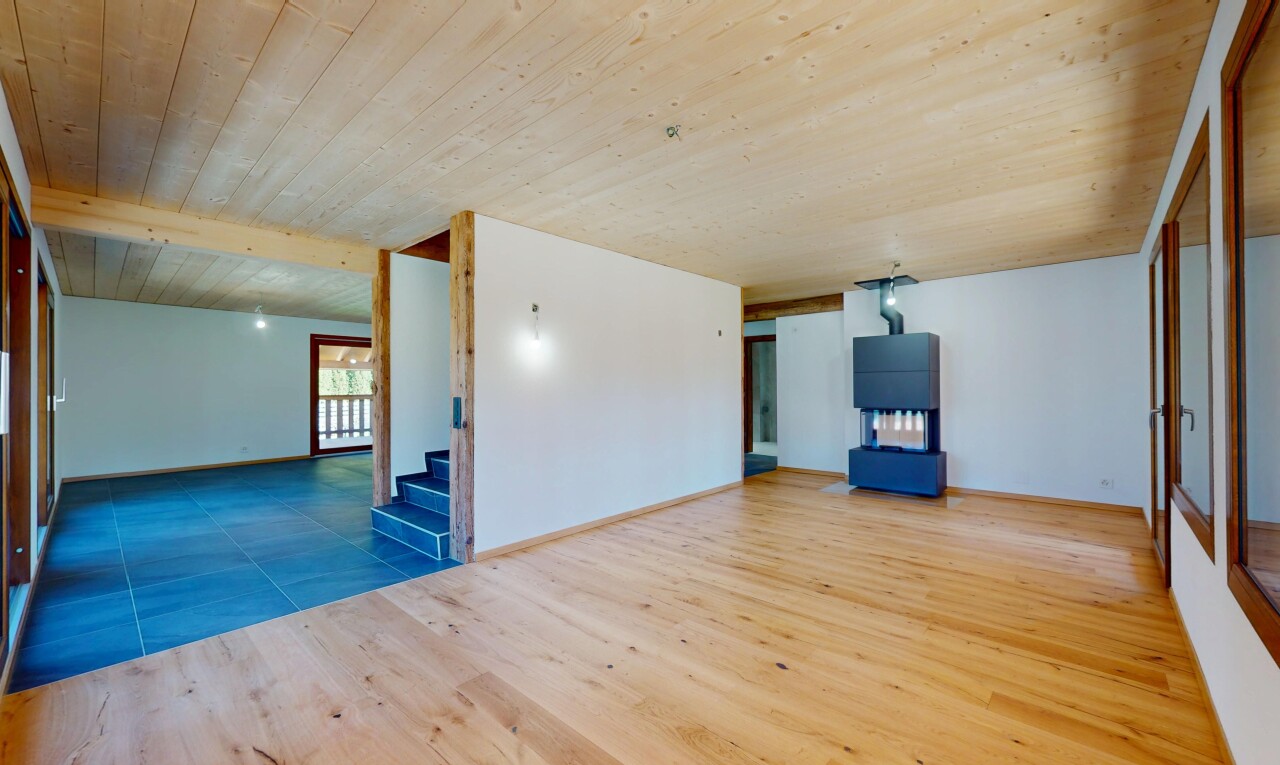 pièce vide avec cloison sèche, lumière naturelle, plafond en bois, et escaliers