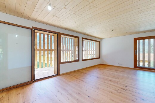 pièce vide avec lumière naturelle, plafond en bois, cloison sèche, et sol en finition bois