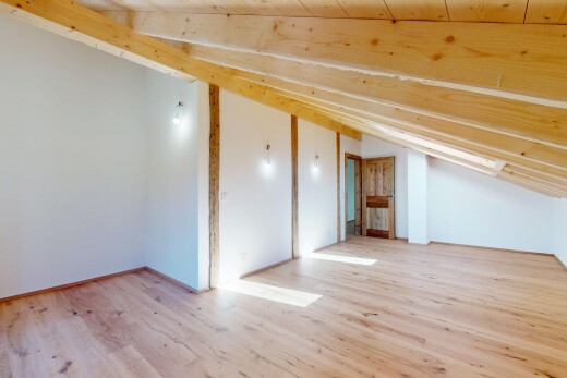 pièce vide avec cloison sèche, plafond voûté, et sol en finition bois