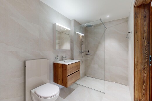salle de bains avec évier, douche, lavabo (ou coiffeuse selon le contexte), mur en carrelage, et miroir