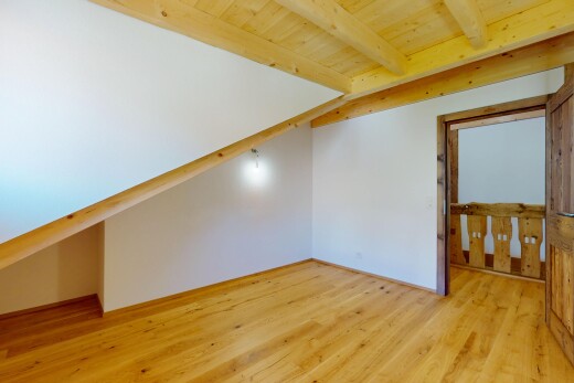 pièce vide avec cloison sèche, plafond en bois, plafond à poutres, et sol en finition bois