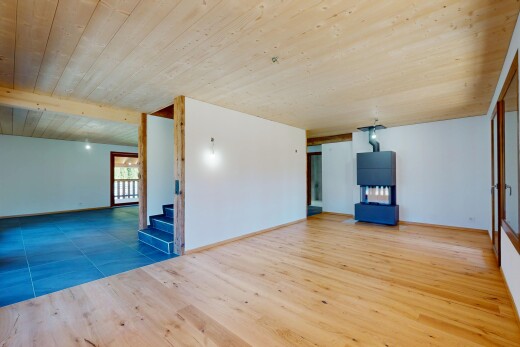 pièce vide avec cloison sèche, lumière naturelle, plafond en bois, et escaliers