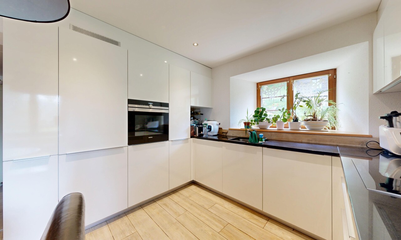 cuisine avec four, plans de travail, dark countertops, light floor, et sol en finition bois