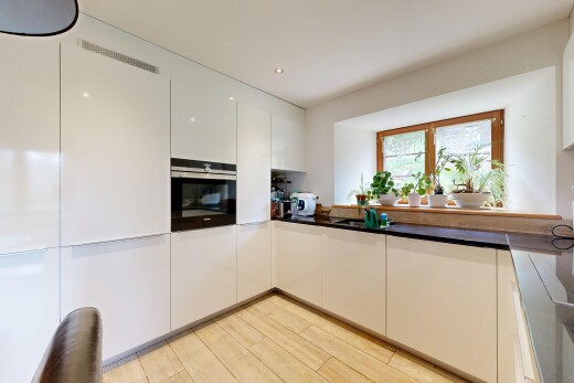 cuisine avec four, plans de travail, dark countertops, light floor, et sol en finition bois
