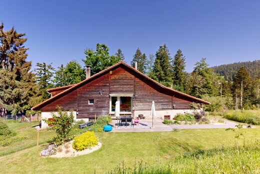 outdoor house featuring a yard, a patio area, and a chimney