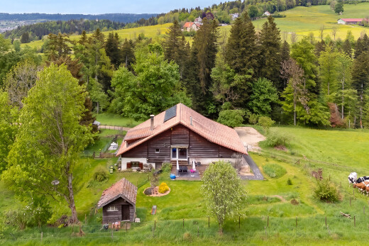 façade avec property visible, pelouse, structure extérieure, bardage horizontal, et rural view