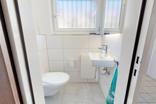 salle de bains avec toilette, inside property, évier, mur en carrelage, et tile wall