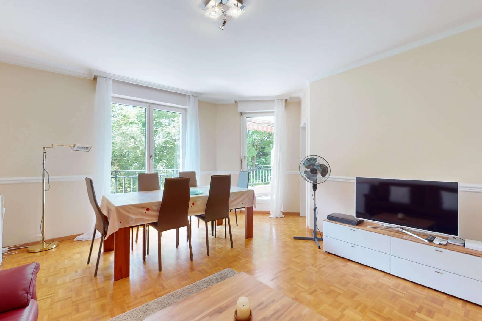 wohn- / esszimmer mit parkettboden, fernsehen, und natürliches licht