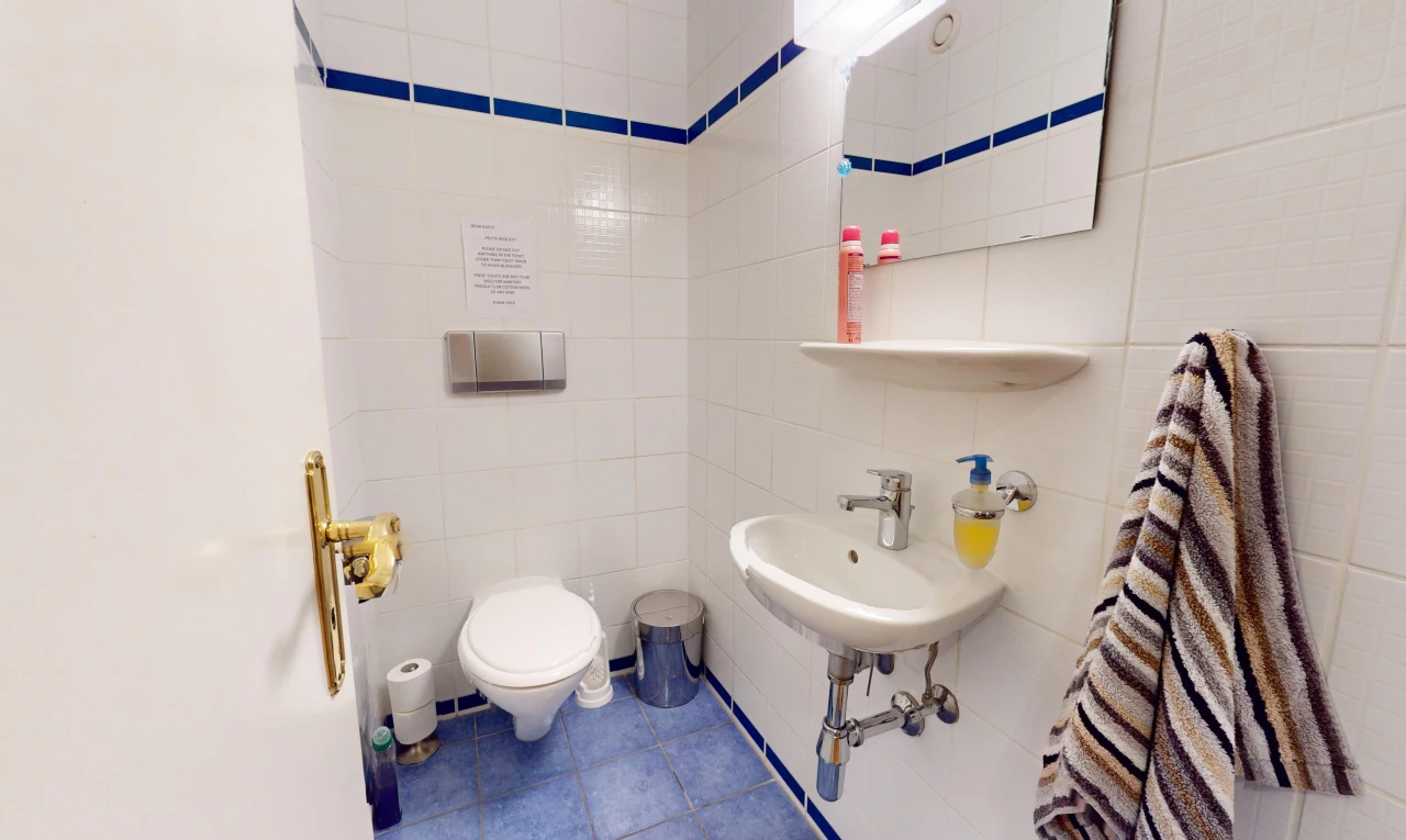 bad mit spiegel, fliesenboden, toilette, und fliesenwand