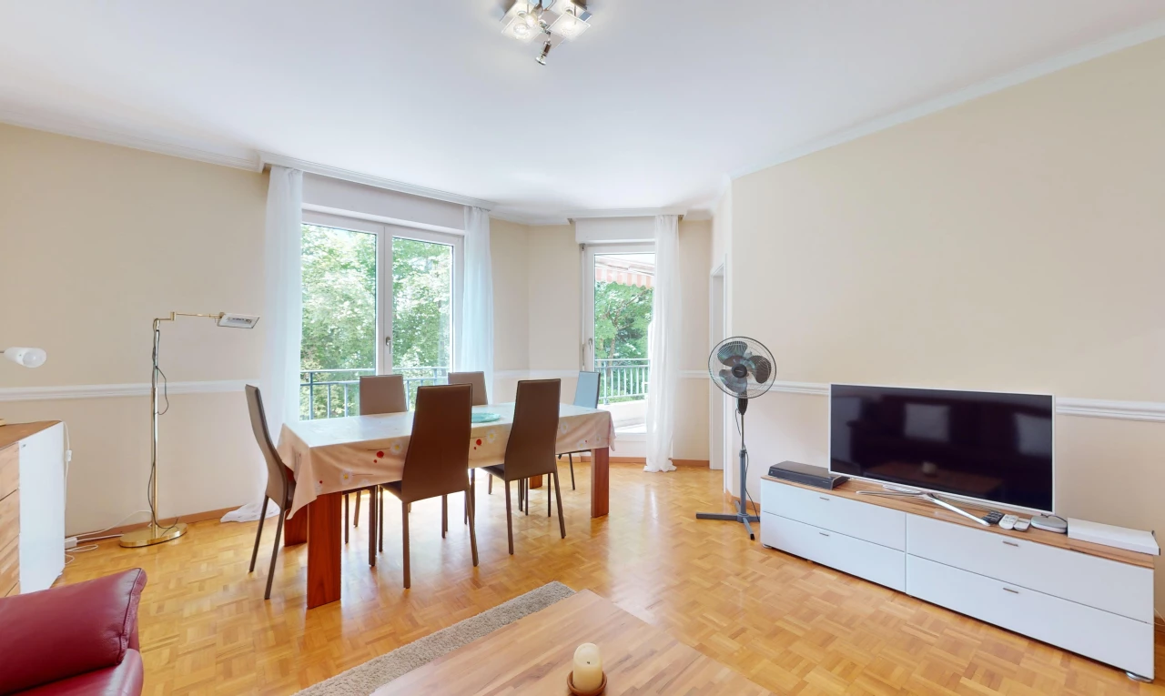 wohn- / esszimmer mit parkettboden, fernsehen, und natürliches licht