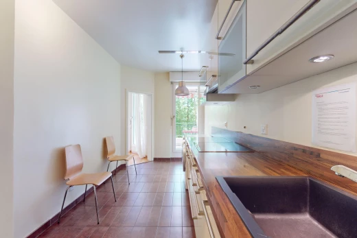 cuisine avec suspension, cuisinière, carrelage, lumière naturelle, et vasque