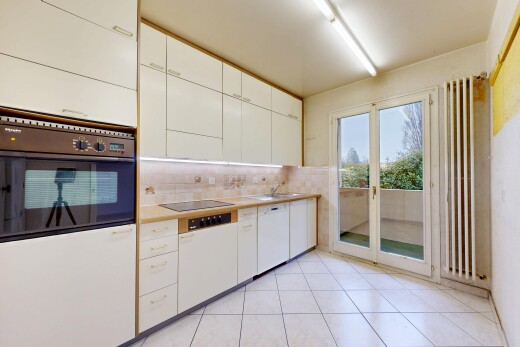 cuisine avec four, armoires blanches, plans de travail, day time, et lumière naturelle