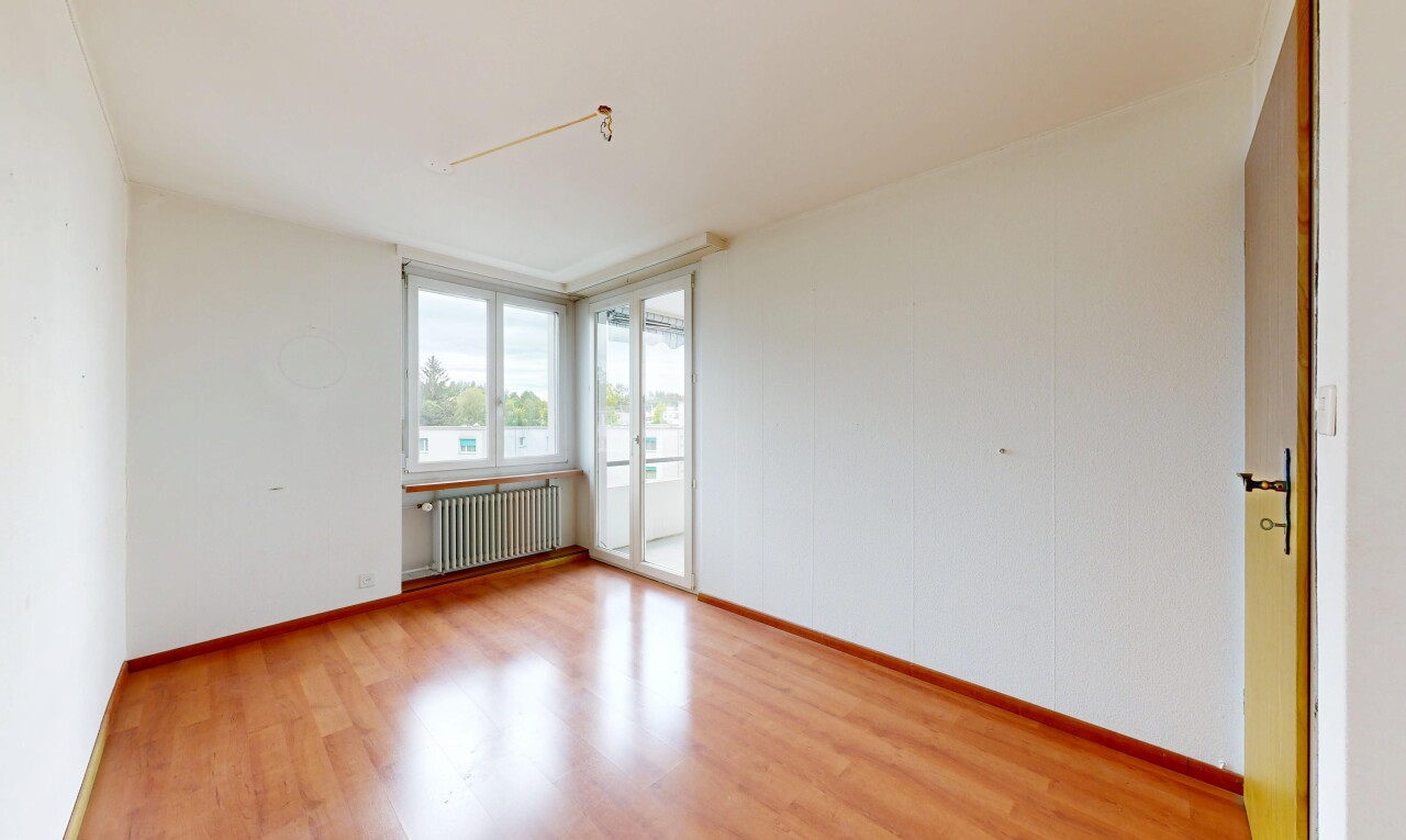 pièce vide avec lumière naturelle, natural light, sol en finition bois, wood finish floor, et radiateur