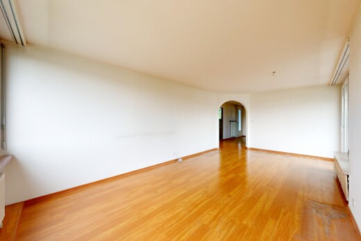 leerer raum mit gewölbte gehwege, holzfußboden, wood finish floor, inside property, und gipskartonwand