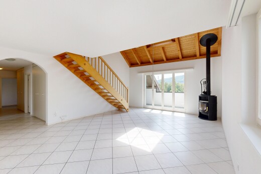 leerer raum mit gewölbte gehwege, gipskartonwand, drywall, holzofen, und natürliches licht