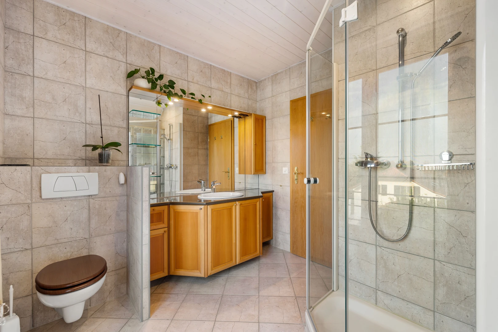 salle de bains avec carrelage, mur carrelé, vasque, douche, et meuble-lavabo