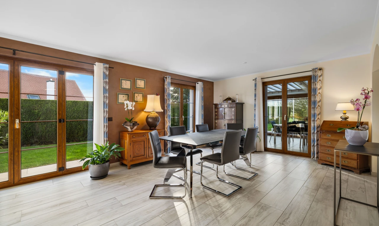 salle à manger avec lumière naturelle, porte-fenêtre, et plancher de bois