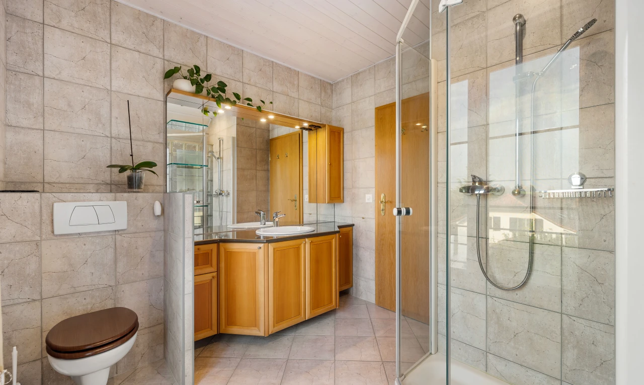salle de bains avec carrelage, mur carrelé, vasque, douche, et meuble-lavabo