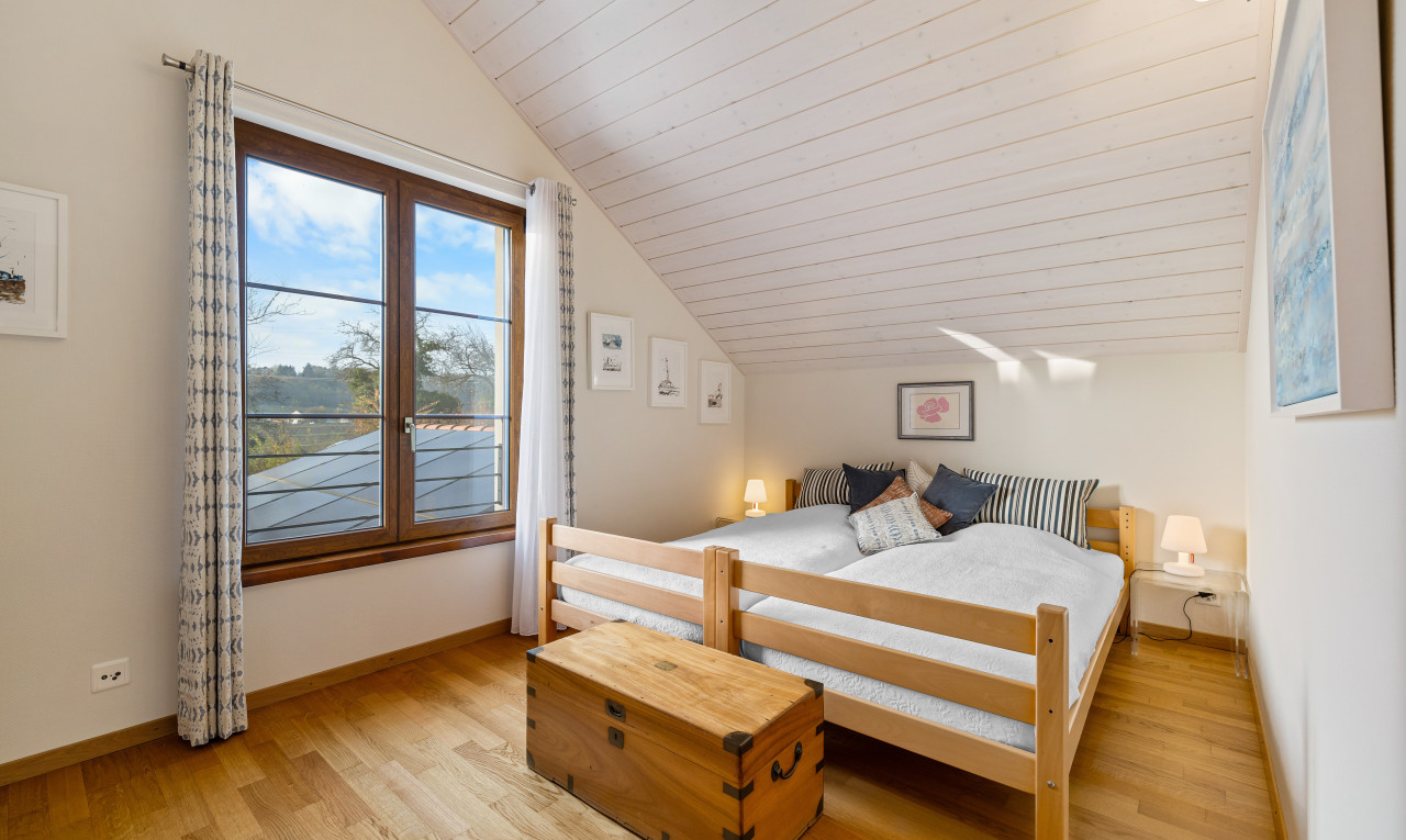 chambre avec lumière naturelle, plafond voûté, plafond de bois, et plancher de bois