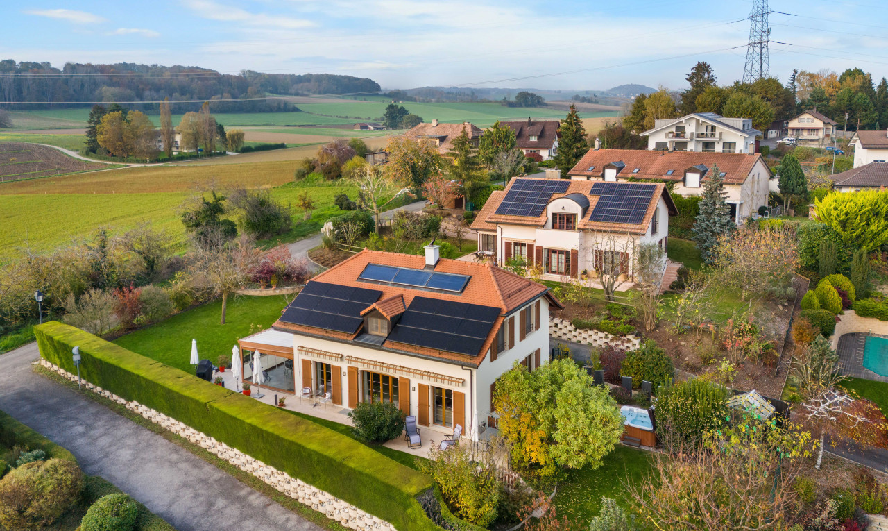 façade avec vue sur lignes à haute tension, pelouse, patio, et panneaux solaires