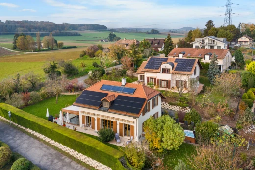 façade avec vue sur lignes à haute tension, pelouse, patio, et panneaux solaires