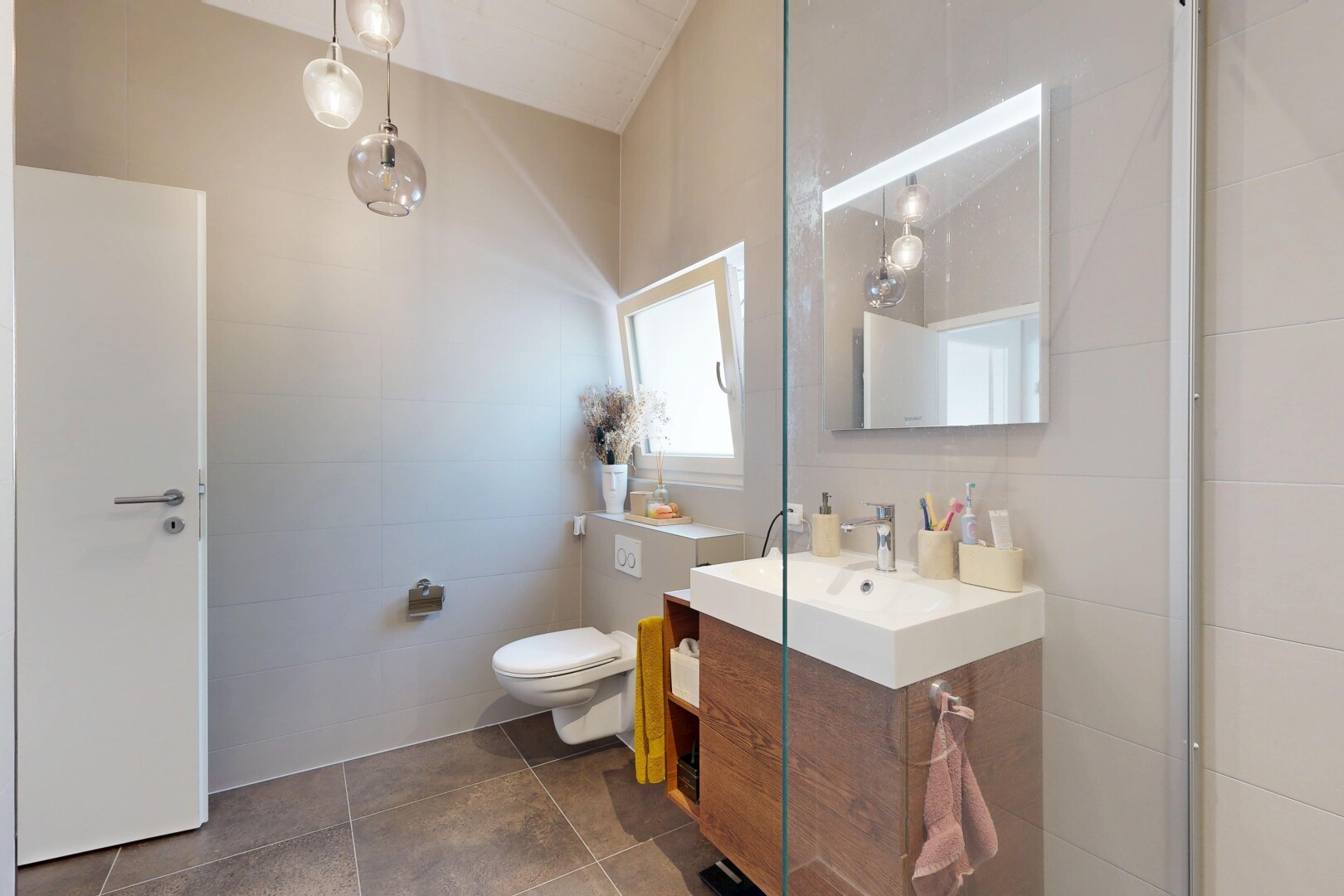 salle de bains avec lavabo (ou coiffeuse selon le contexte), miroir, inside property, lumière naturelle, et natural light