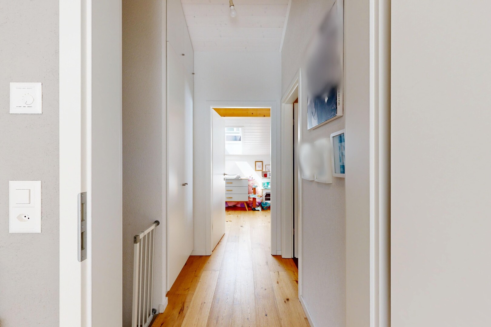 couloir avec sol en finition bois, wood finish floor, cloison sèche, drywall, et inside property
