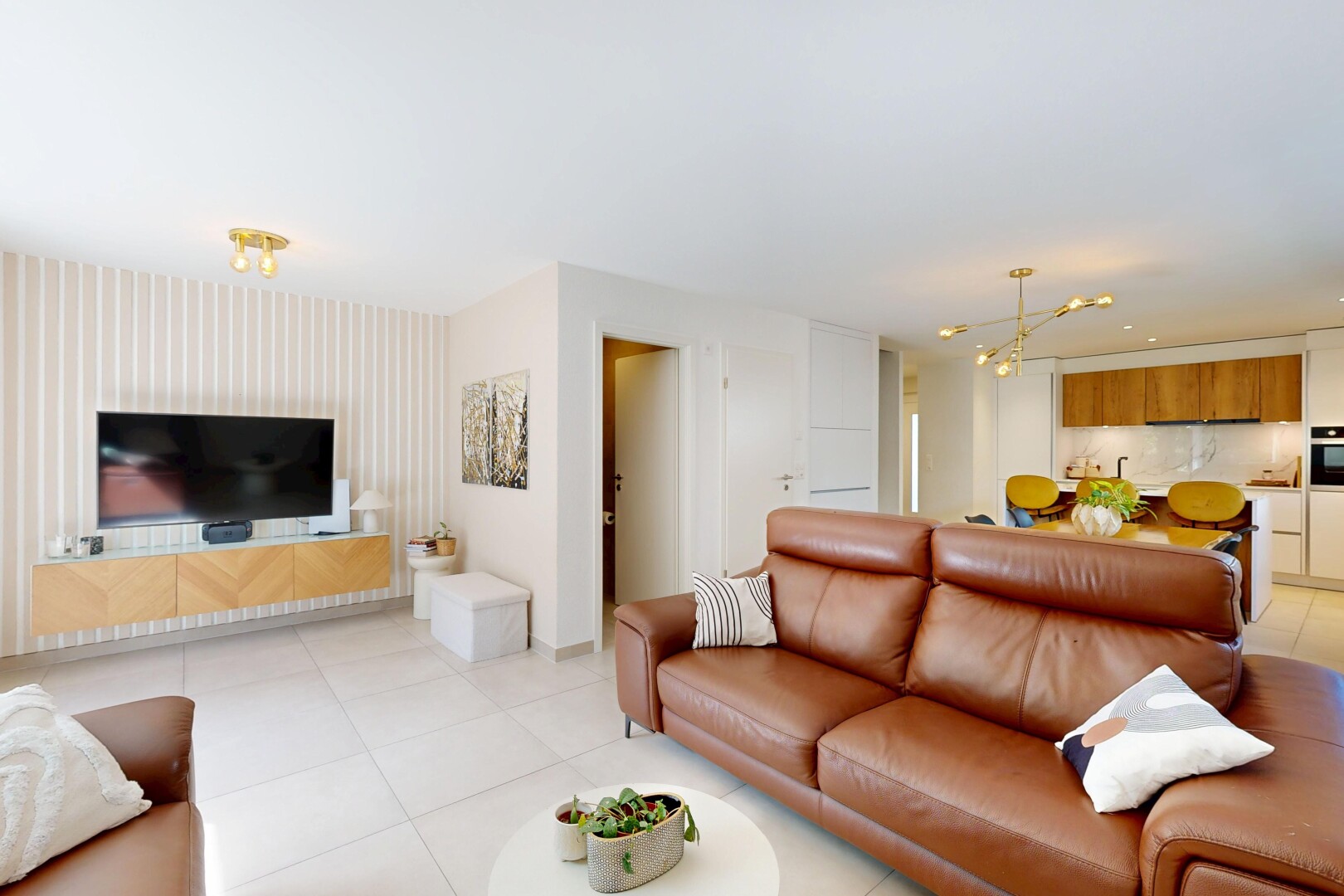 salon avec cloison sèche, drywall, télévision, inside property, et light floor