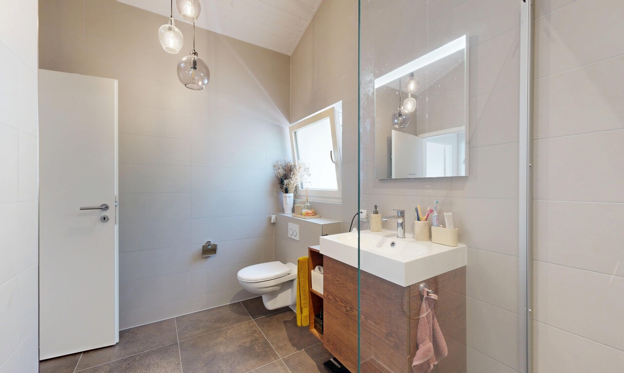salle de bains avec lavabo (ou coiffeuse selon le contexte), miroir, inside property, lumière naturelle, et natural light