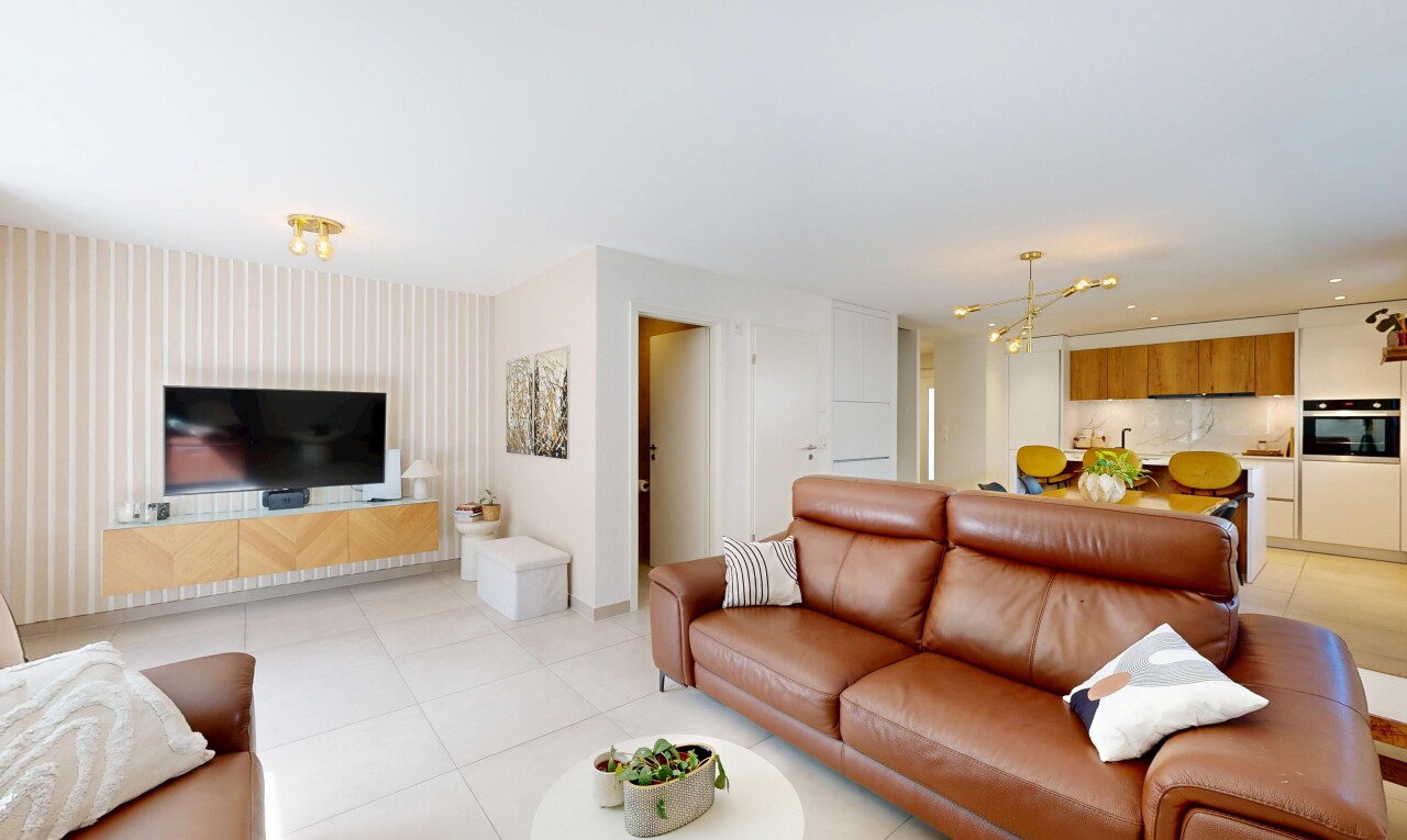 salon avec cloison sèche, drywall, télévision, inside property, et light floor