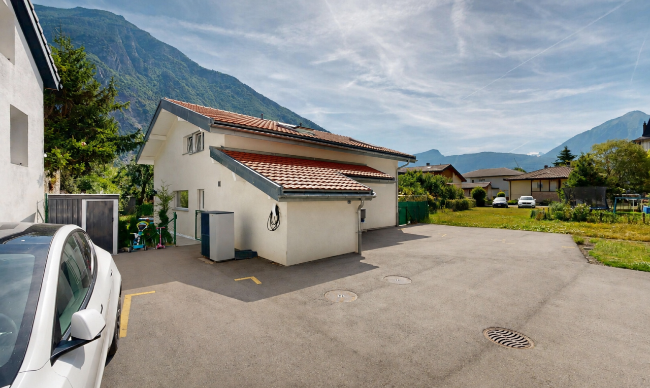 outdoor house with a tiled roof, a mountain view, and stucco siding