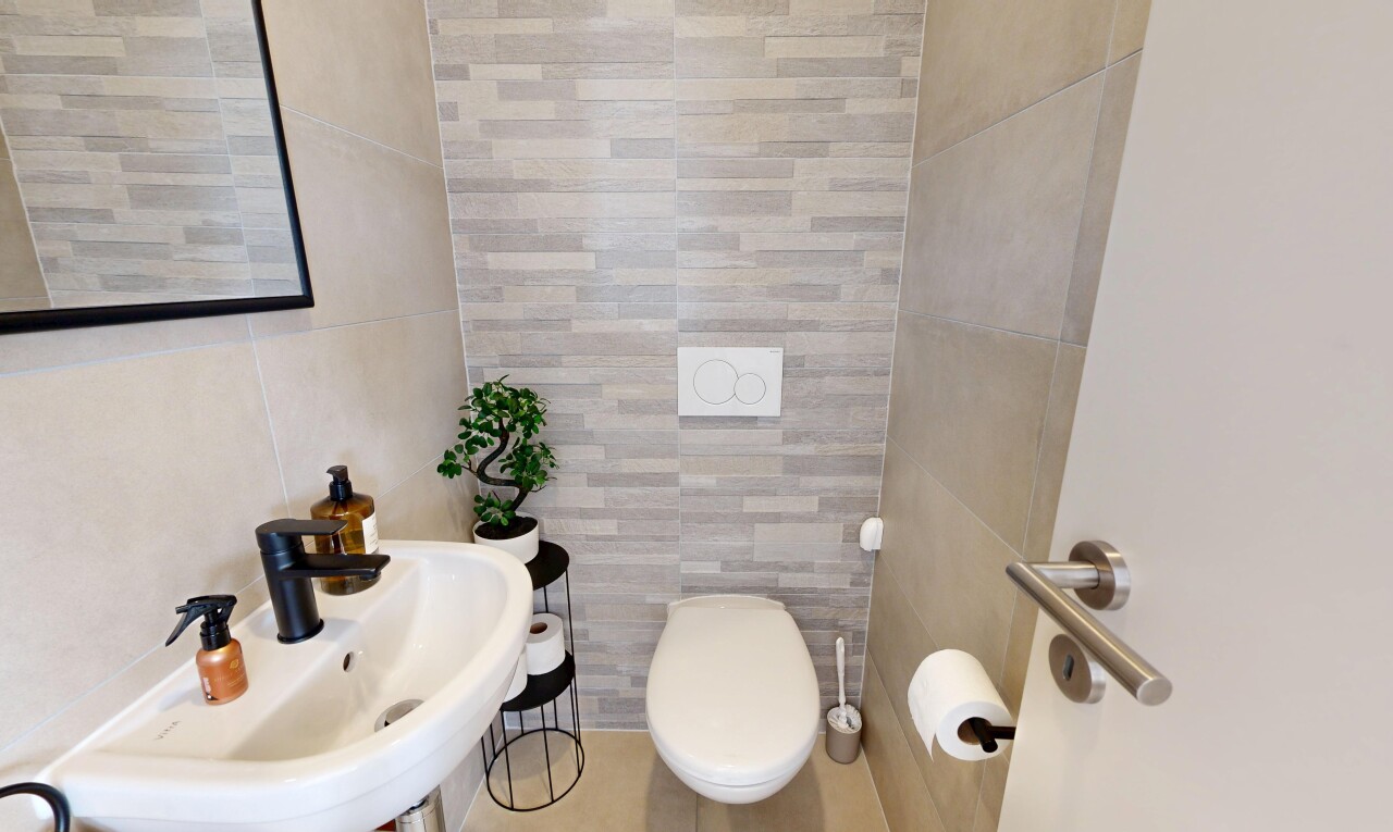 salle de bains avec mur en carrelage, tile wall, évier, inside property, et toilette
