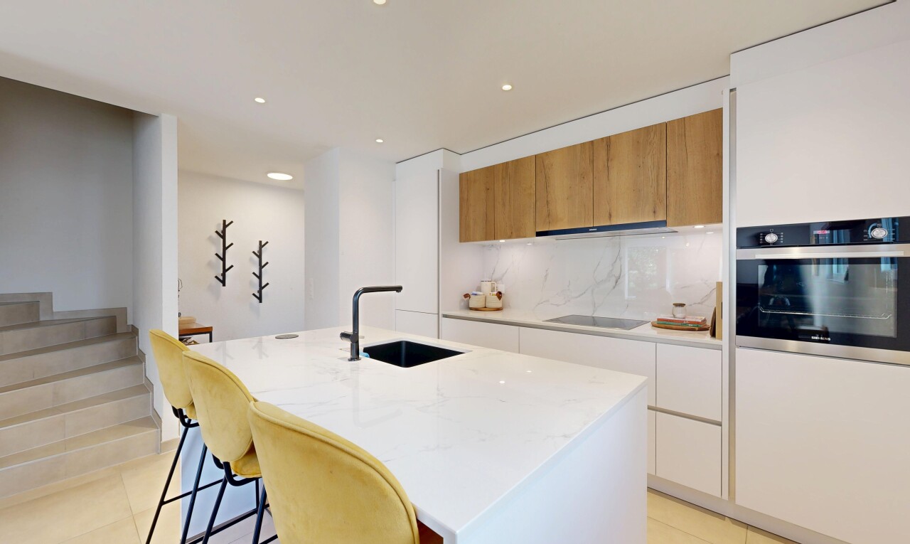 cuisine avec light floor, flat panel cabinets, armoires à panneau plat, four, et light countertops