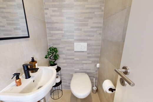 salle de bains avec mur en carrelage, tile wall, évier, inside property, et toilette
