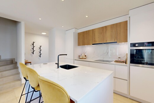 cuisine avec light floor, flat panel cabinets, armoires à panneau plat, four, et light countertops