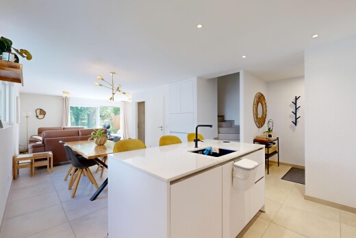 cuisine avec armoires blanches, white cabinets, light countertops, light floor, et îlot de cuisine