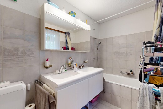bathroom featuring double vanity, tile walls, and tiled shower / bath