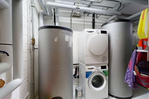 laundry room with water heater and stacked washer / drying machine