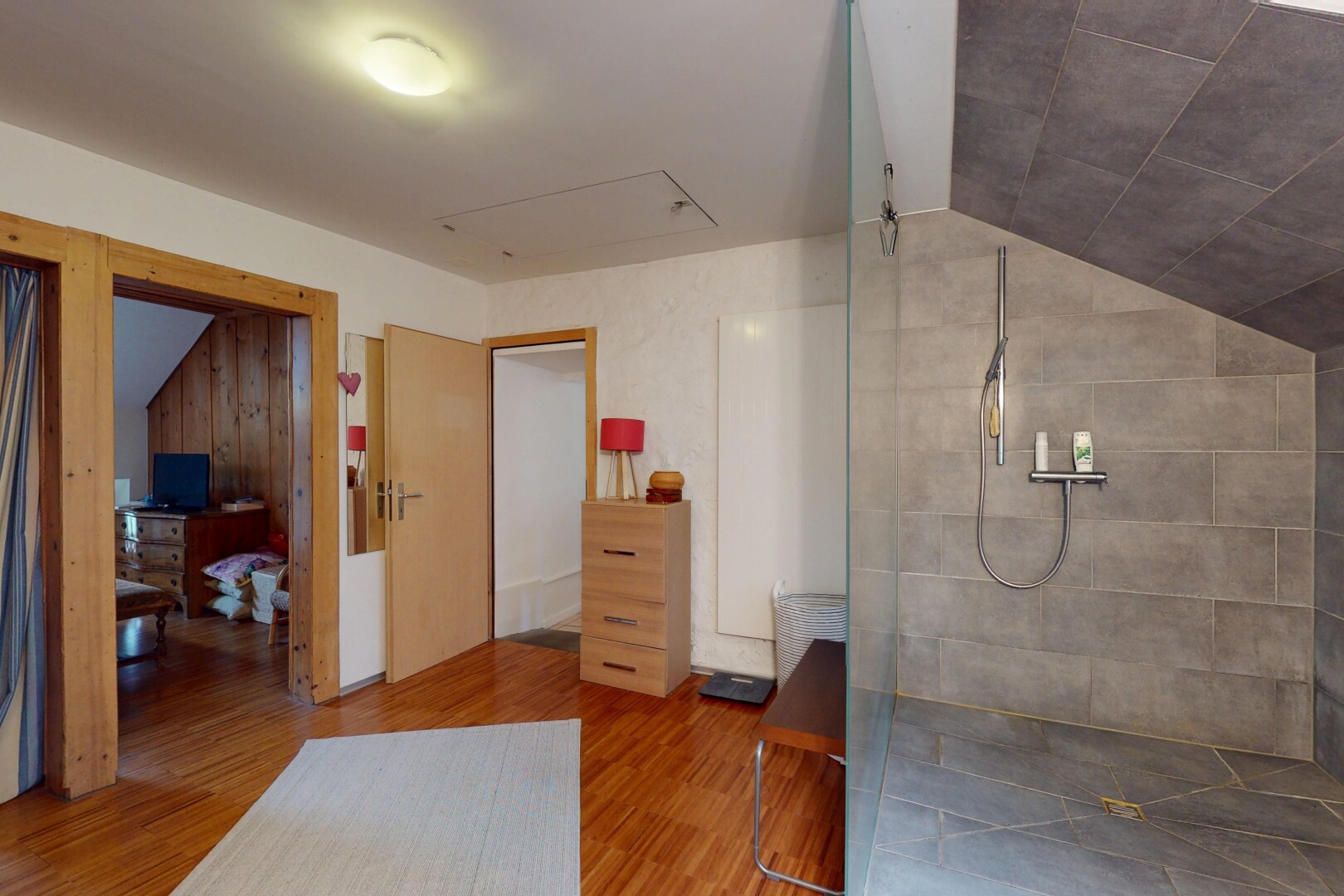 full bathroom featuring lofted ceiling, walk in shower, and wood finished floors