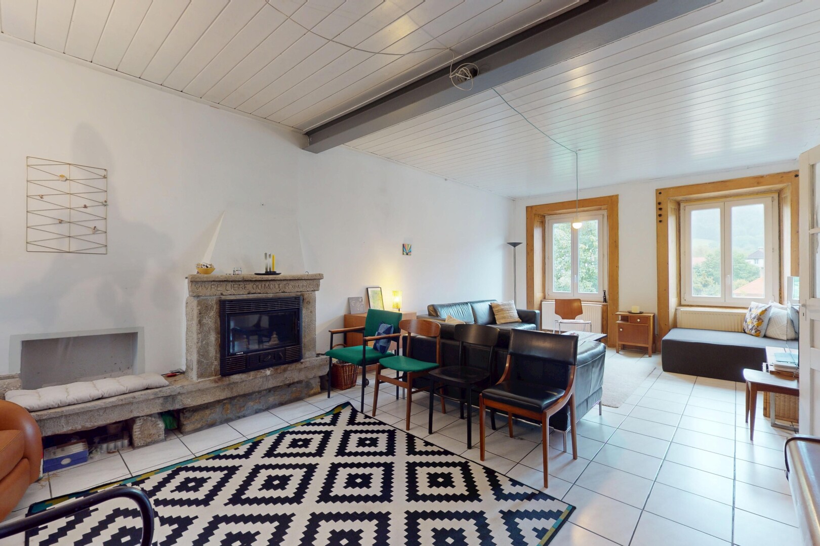 living room featuring a glass covered fireplace, a wood ceiling with exposed beams, and light tile patterned flooring