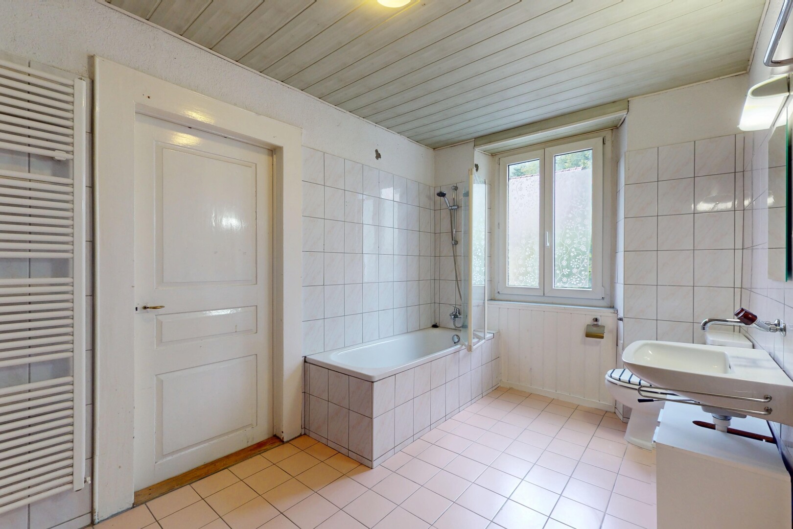 full bathroom featuring radiator heating unit, tile patterned floors, tiled shower / bath combo, tile walls, and a towel warming rack